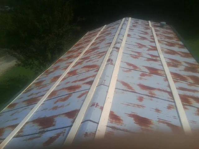 Rusted metal roof panels with new wood purlins before replacement — Storm Damage Roof Repair in Wisner by Roofing Brothers
